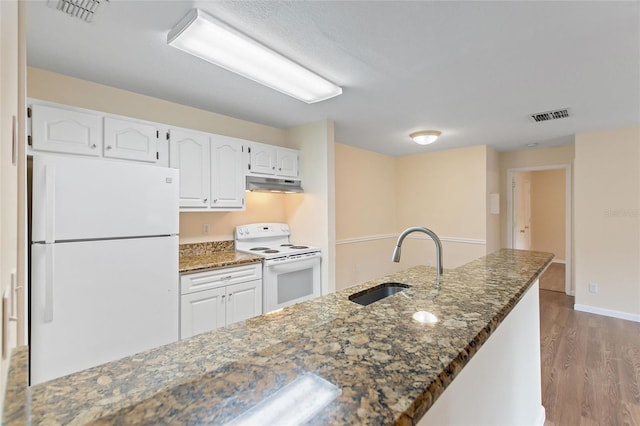 kitchen with white cabinetry, sink, dark hardwood / wood-style floors, dark stone countertops, and white appliances