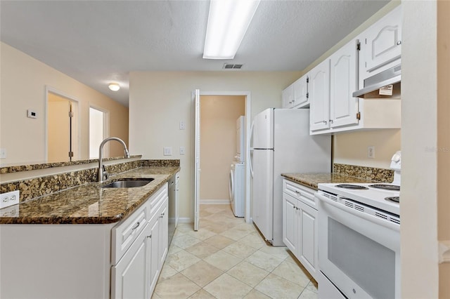 kitchen with white appliances, white cabinetry, dark stone countertops, and sink