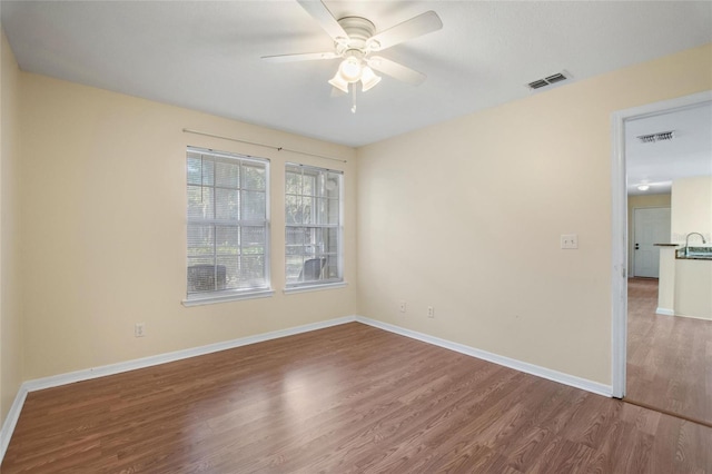 empty room featuring ceiling fan and hardwood / wood-style floors