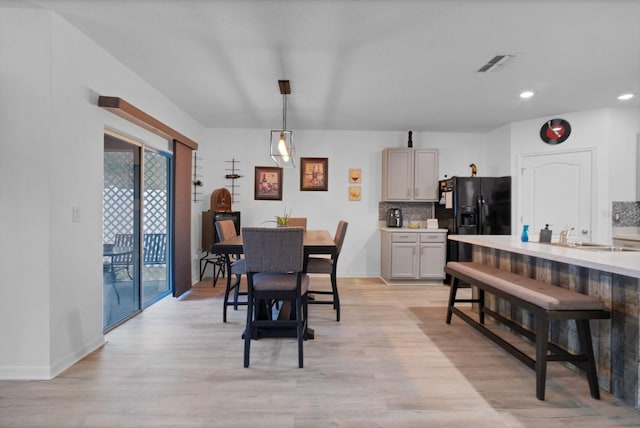 dining room with sink and light hardwood / wood-style floors