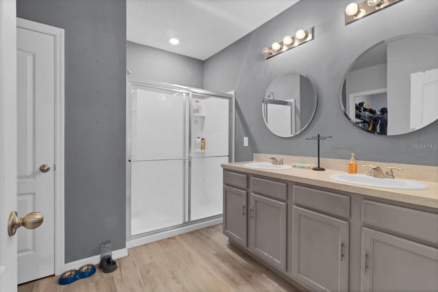 bathroom with vanity, hardwood / wood-style flooring, and a shower with door