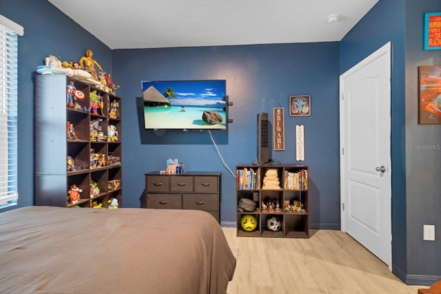 bedroom featuring light hardwood / wood-style floors and multiple windows