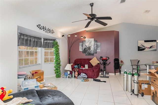 living room with ceiling fan, lofted ceiling, and light tile patterned floors