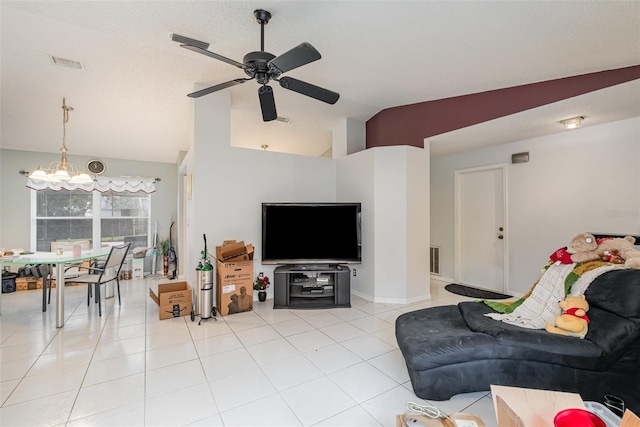 tiled living room featuring ceiling fan with notable chandelier and vaulted ceiling