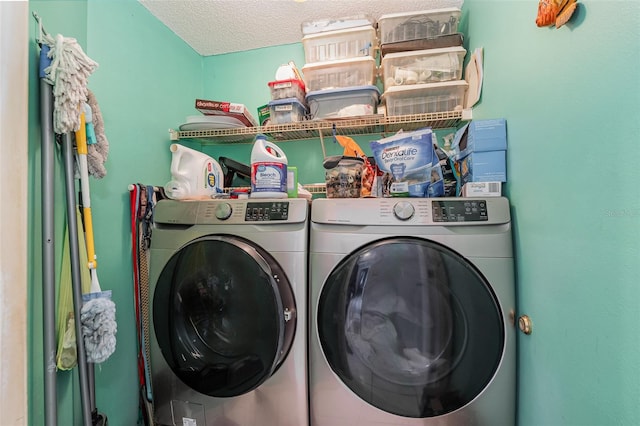 washroom featuring washer and clothes dryer and a textured ceiling