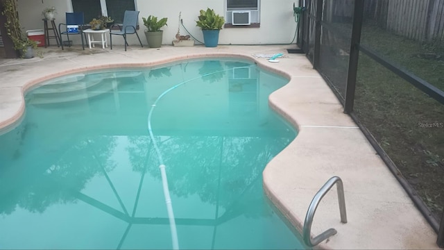 view of swimming pool featuring a patio area and cooling unit