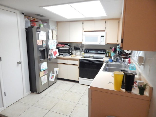 kitchen featuring light tile patterned floors, white appliances, a skylight, and sink