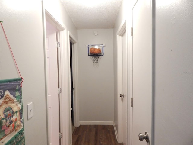 hallway featuring a textured ceiling and dark wood-type flooring