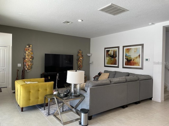 living room with a textured ceiling and light tile patterned floors