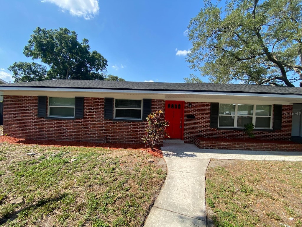 single story home featuring a front lawn