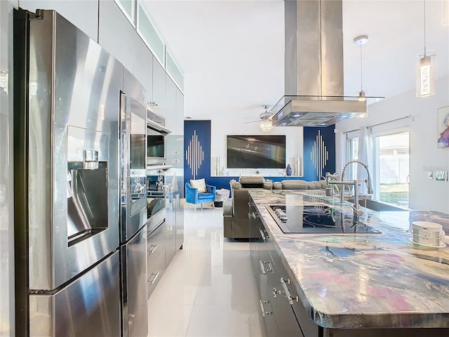 kitchen with pendant lighting, light tile patterned flooring, black appliances, sink, and island range hood