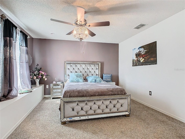 carpeted bedroom featuring ceiling fan and a textured ceiling