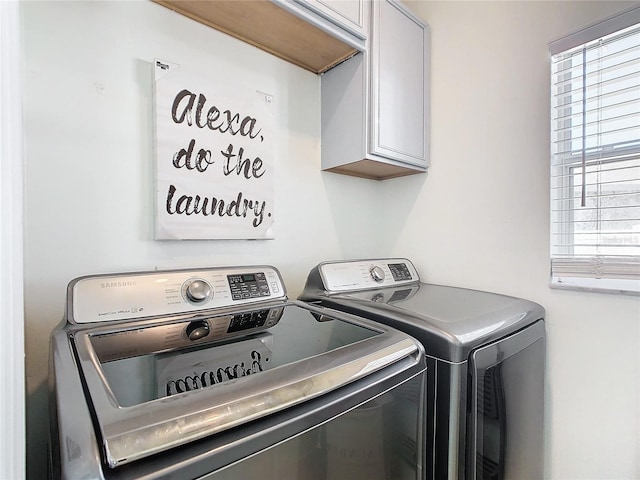 laundry room featuring washer and clothes dryer and cabinets