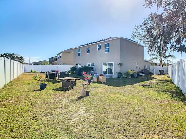 rear view of house featuring a yard and central AC unit