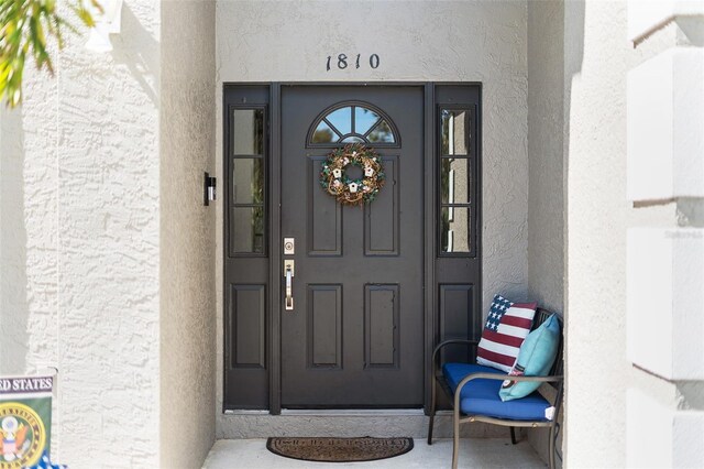 doorway to property featuring stucco siding