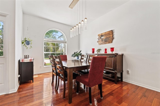 dining space with baseboards and hardwood / wood-style floors