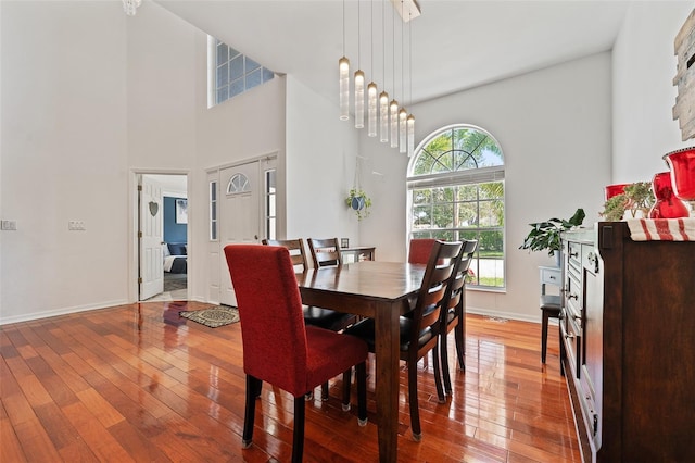 dining room with plenty of natural light, baseboards, and hardwood / wood-style flooring