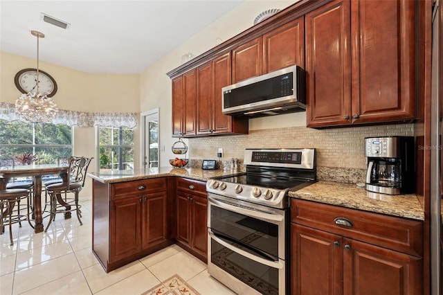 kitchen featuring stainless steel appliances, a peninsula, visible vents, decorative backsplash, and light stone countertops