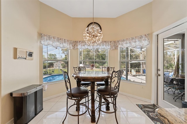 dining area with baseboards, a notable chandelier, and light tile patterned flooring