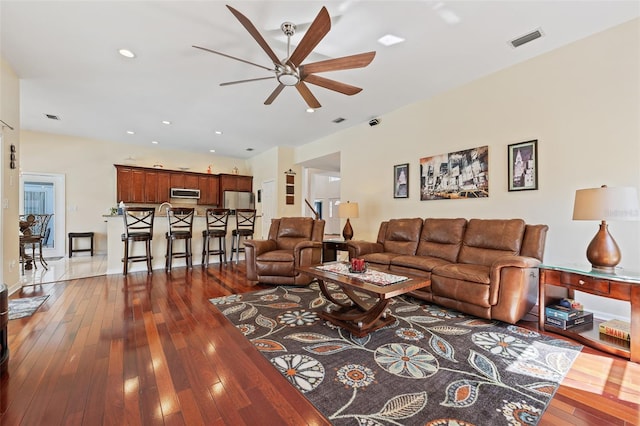 living room with dark wood-type flooring, recessed lighting, visible vents, and a ceiling fan