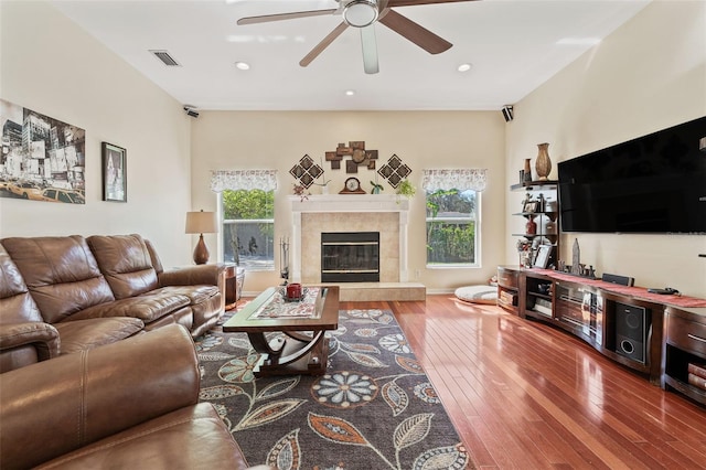 living room featuring hardwood / wood-style floors, a fireplace, visible vents, and a wealth of natural light