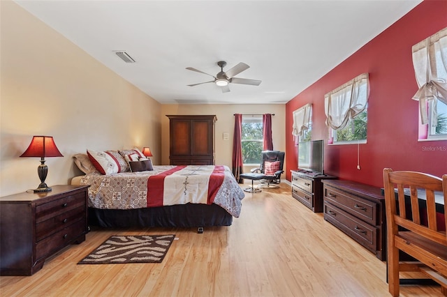 bedroom with ceiling fan, light wood-style flooring, and visible vents