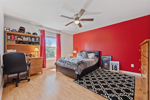 bedroom featuring a ceiling fan, baseboards, and wood finished floors