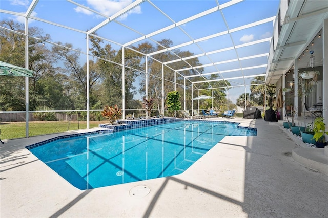 pool featuring glass enclosure and a patio area