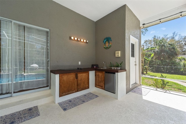 interior space featuring a textured wall and fridge