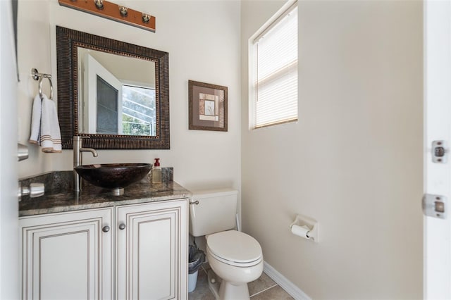 bathroom featuring tile patterned flooring, baseboards, vanity, and toilet