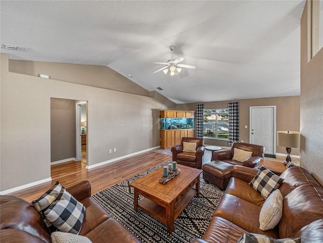 living room featuring ceiling fan, hardwood / wood-style floors, and vaulted ceiling