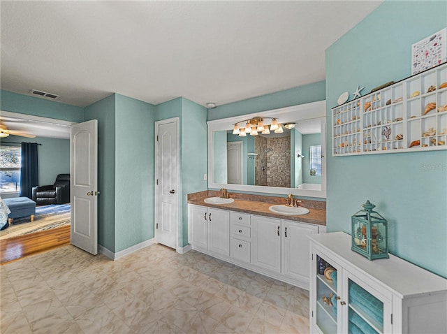 bathroom with ceiling fan, vanity, and walk in shower