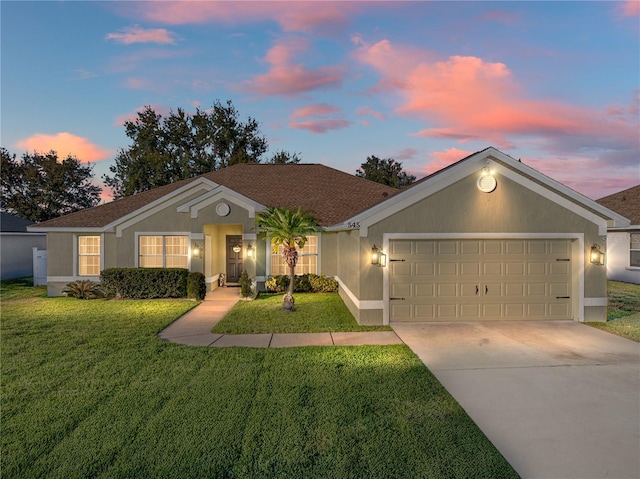 ranch-style house featuring a garage and a yard