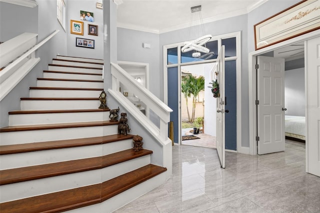 foyer with a chandelier and crown molding