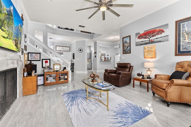 living room featuring ceiling fan, a fireplace, crown molding, and wood-type flooring