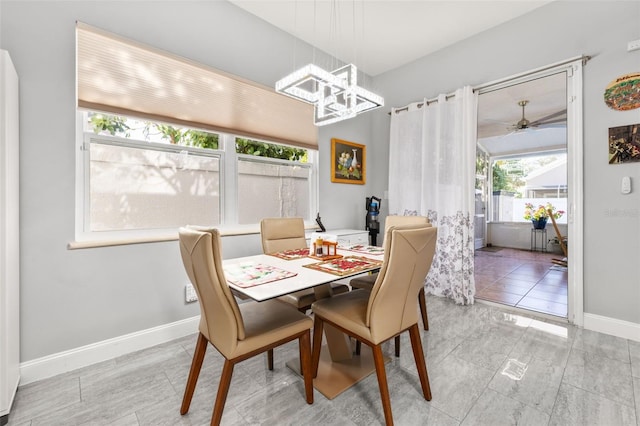 dining area featuring ceiling fan with notable chandelier and light tile patterned flooring