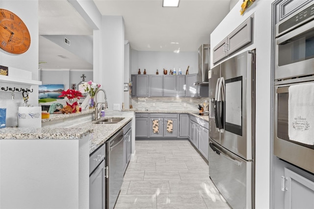 kitchen featuring gray cabinets, decorative backsplash, sink, and appliances with stainless steel finishes