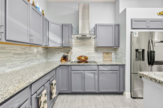 kitchen featuring gray cabinets, black electric cooktop, stainless steel fridge with ice dispenser, and wall chimney exhaust hood