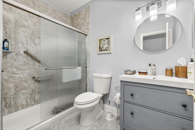 bathroom with a shower with door, vanity, and toilet