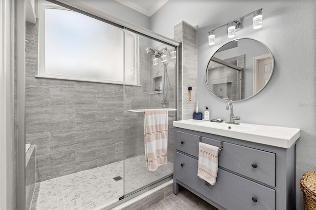 bathroom with ornamental molding, vanity, and a shower with shower door