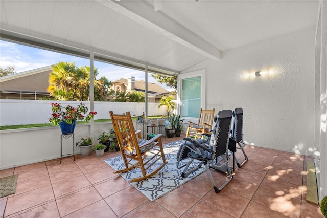 sunroom featuring lofted ceiling with beams