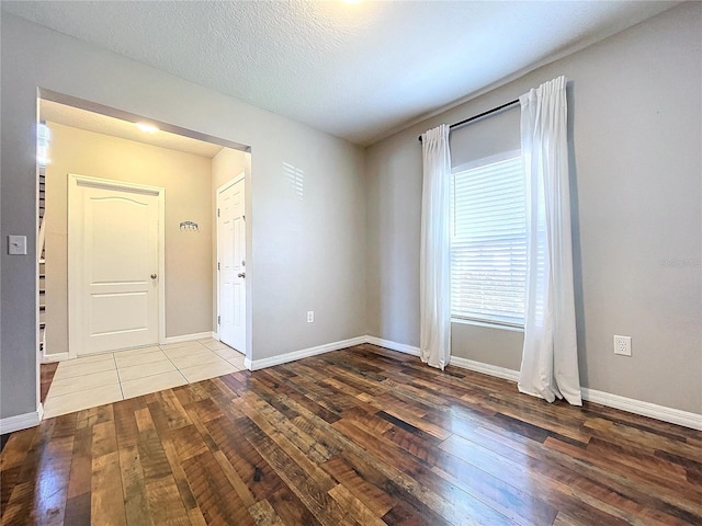 spare room with wood-type flooring and a textured ceiling