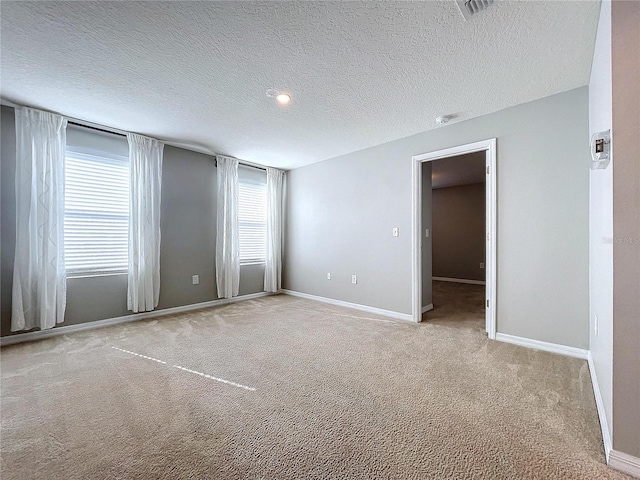 carpeted spare room with a textured ceiling