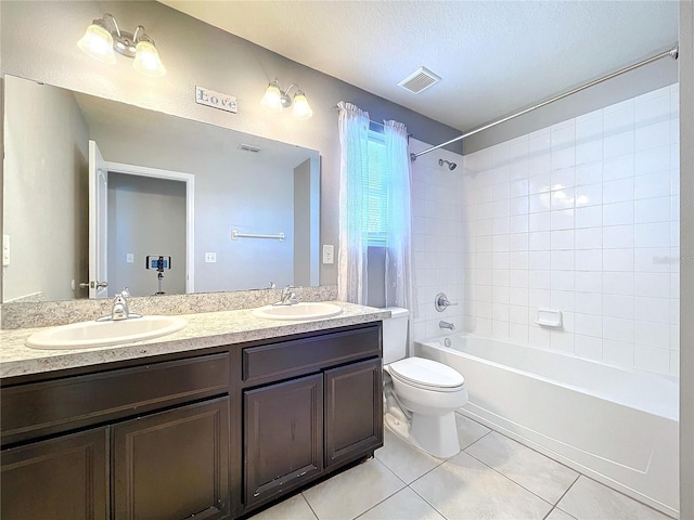 full bathroom with tile patterned floors, vanity, a textured ceiling, toilet, and tiled shower / bath