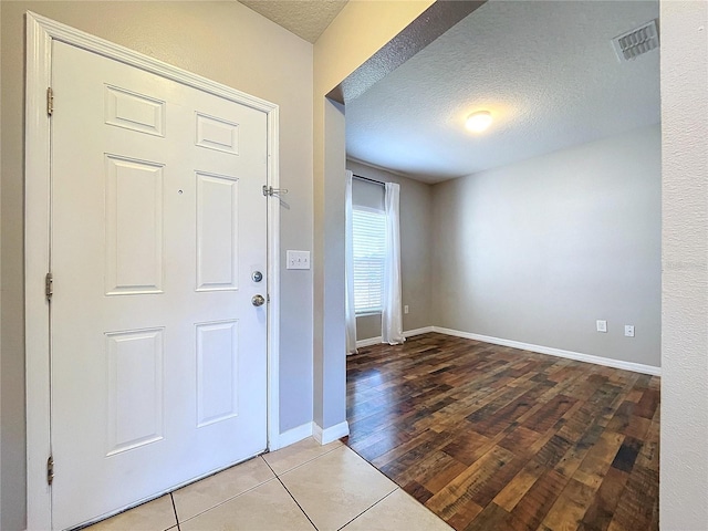 foyer entrance featuring wood-type flooring and a textured ceiling