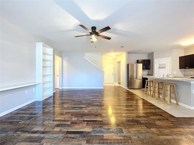 unfurnished living room with dark hardwood / wood-style floors and ceiling fan