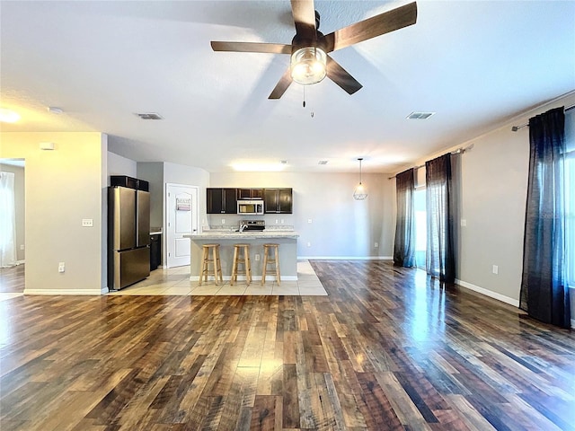 unfurnished living room featuring hardwood / wood-style flooring and ceiling fan