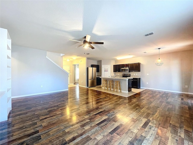 unfurnished living room with dark hardwood / wood-style floors and ceiling fan