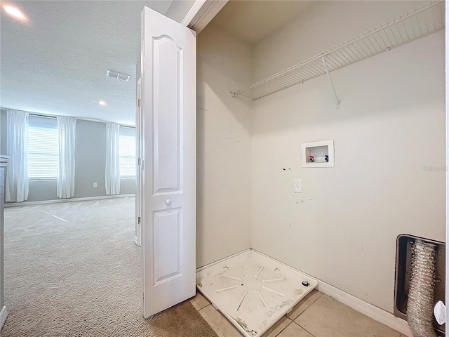 washroom with washer hookup, carpet flooring, and a textured ceiling