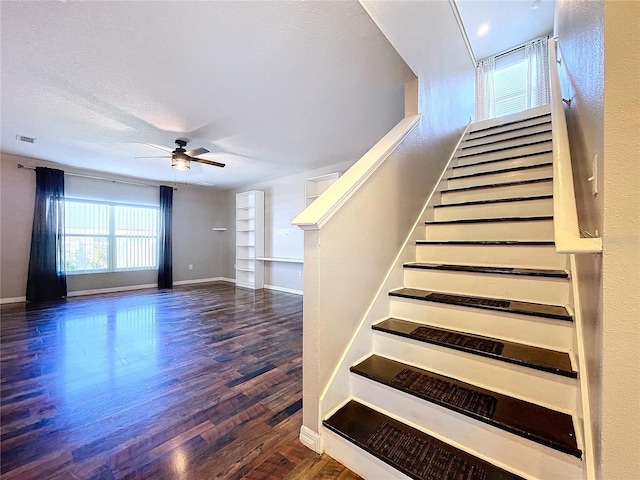 stairway featuring hardwood / wood-style flooring, ceiling fan, and a textured ceiling